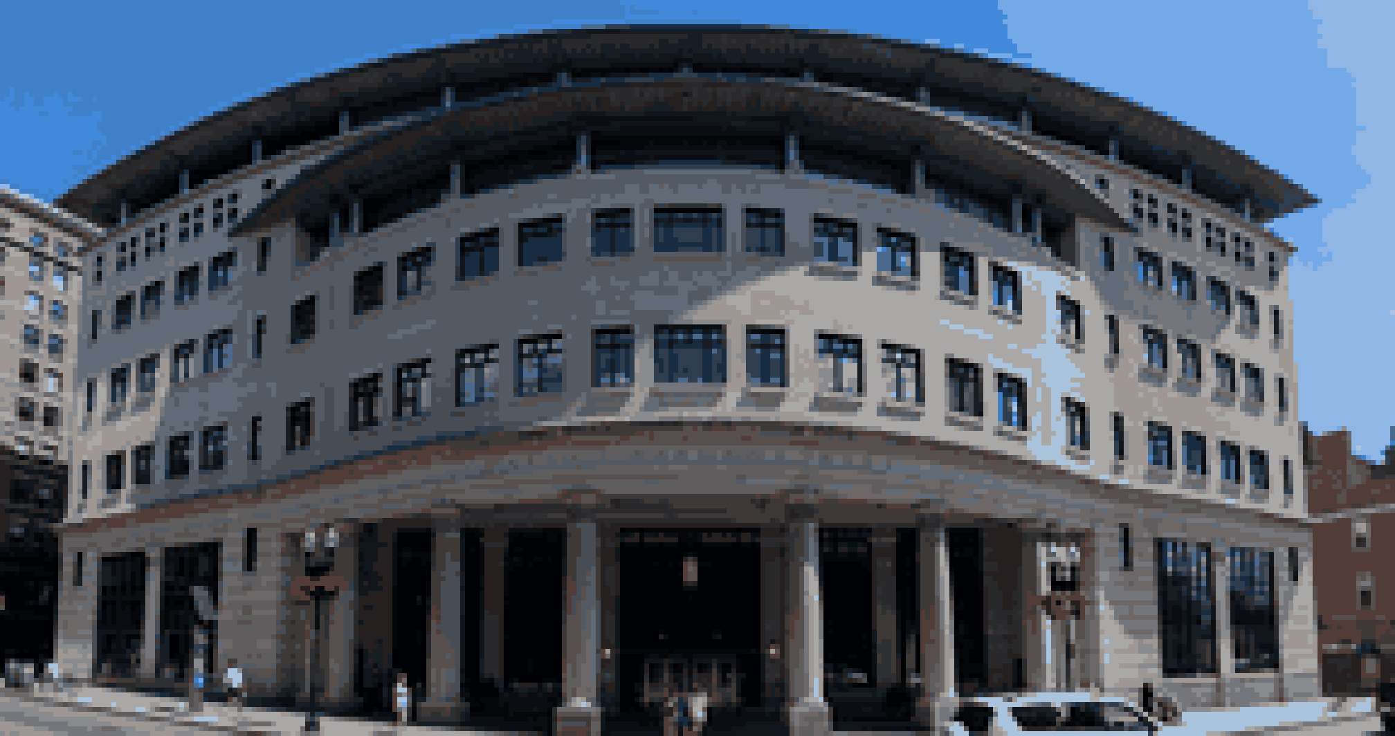 David J. Sargent Hall, Suffolk University Law School, on Tremont Street in Boston: a curved stone facade under a wide overhanging roof, with columns across the entrance and brick buildings on either side.